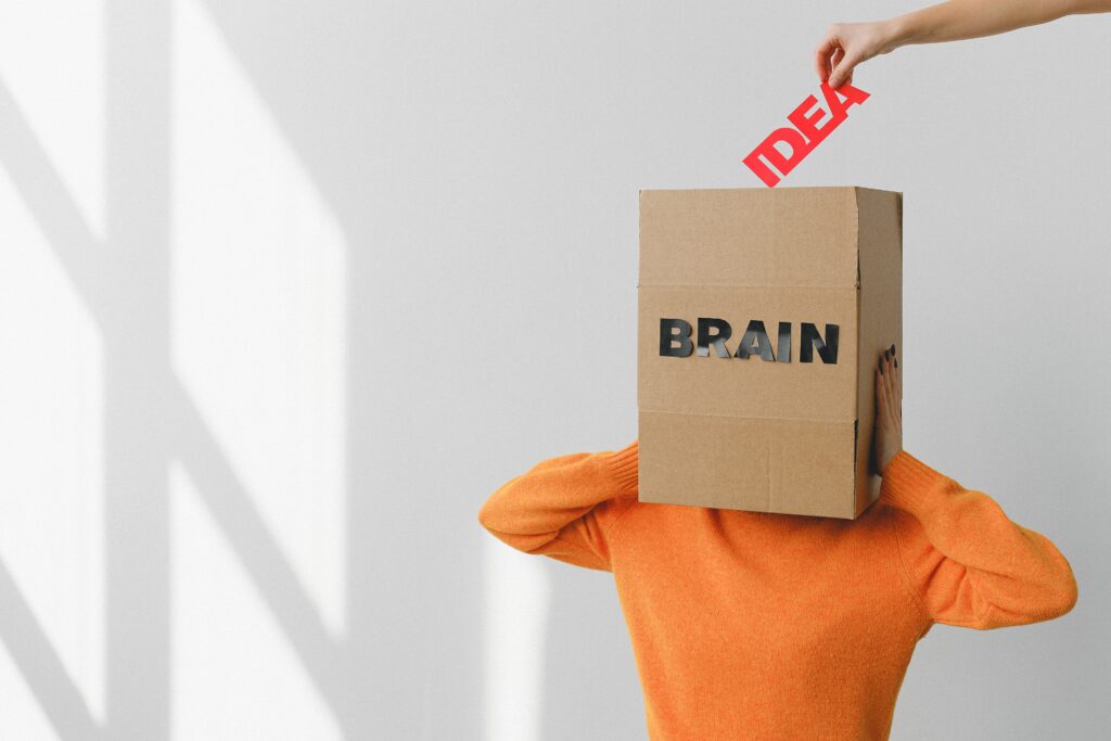Box on a person head that says brain
