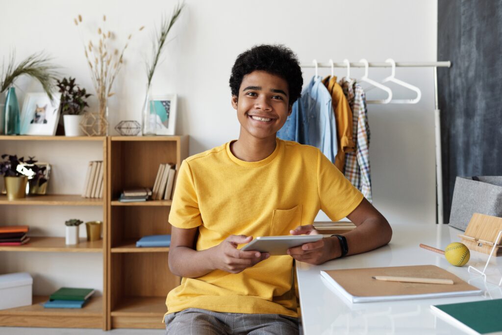 young teenage African american boy smiling wearing a yellow shirt