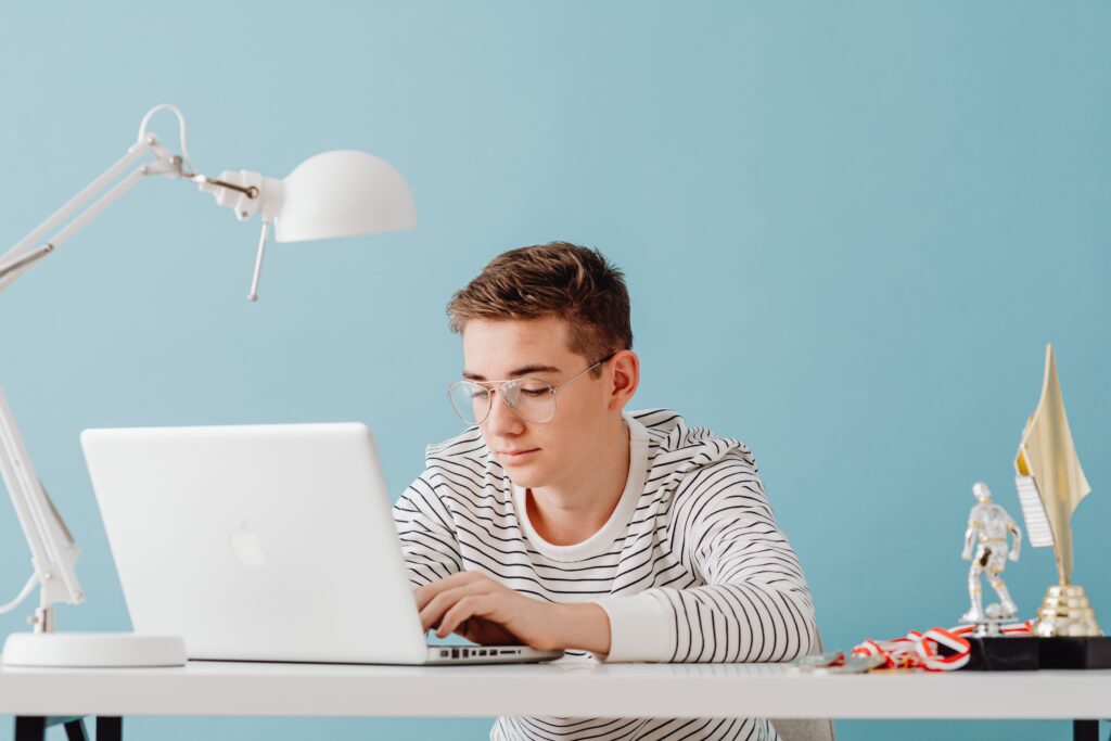 young teenage boy typing on a computer
