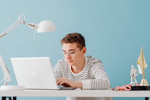 young teenage boy typing on a computer